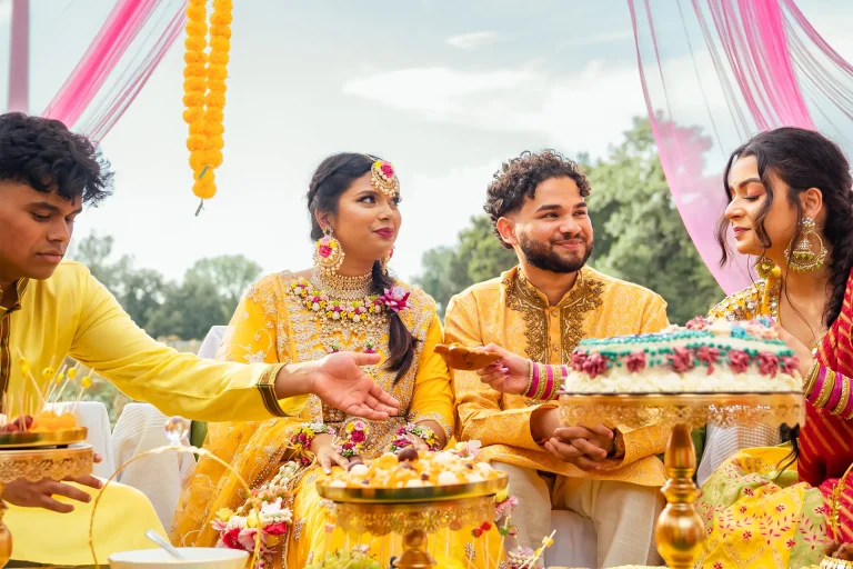 Eine Gruppe von Menschen, die bei einer indischen Hochzeit einen Kuchen essen.